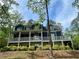 Spacious two-story home with a large porch, lower patio area, and lush landscaping at 4101 Brookview Se Dr, Atlanta, GA 30339
