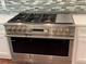 Stainless steel oven with gold knobs and white cabinets and glass tile backsplash in the background at 4101 Brookview Se Dr, Atlanta, GA 30339