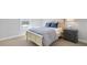 This bedroom features a light-colored bed, a gray dresser, neutral walls, carpet, and a window at 605 Vidalia Pkwy, Mcdonough, GA 30252