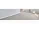 A sitting area features two armchairs, a small table, neutral walls, carpet, and a staircase in the background at 605 Vidalia Pkwy, Mcdonough, GA 30252