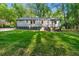 Spacious backyard with lush green lawn, mature trees, a detached garage, and a partial fence at 1186 Thomas Rd, Decatur, GA 30030