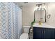Cozy bathroom offers a shower with patterned curtain, navy vanity and updated fixtures at 1186 Thomas Rd, Decatur, GA 30030