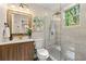 Modern bathroom featuring a glass shower with gold fixtures and a vanity with a wood grain cabinet at 1186 Thomas Rd, Decatur, GA 30030