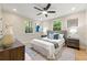 Bright bedroom with a bed, two windows overlooking a forest, and a ceiling fan with recessed lighting at 1186 Thomas Rd, Decatur, GA 30030
