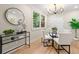 Bright dining room featuring modern lighting fixture, glass table, and serene view from the window at 1186 Thomas Rd, Decatur, GA 30030