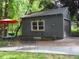 Detached garage with an asphalt driveway, charming gray siding, and a delightful sun decoration at 1186 Thomas Rd, Decatur, GA 30030