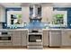 Stylish kitchen with stainless steel appliances, a striking blue backsplash, and ample natural light at 1186 Thomas Rd, Decatur, GA 30030