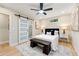 Bedroom with sliding barn door to ensuite, bench seat at end of bed and dual night stands at 1186 Thomas Rd, Decatur, GA 30030