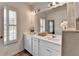Bright bathroom with white cabinets, double sinks, large mirror, and plantation shutters on the window at 3677 Sorrel Ln, Duluth, GA 30096