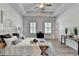 Well-lit bedroom showcases a tray ceiling, two windows, modern decor, and a connecting door at 3677 Sorrel Ln, Duluth, GA 30096