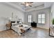 Bright bedroom featuring a tray ceiling, decorative shutters, and a plush upholstered bed at 3677 Sorrel Ln, Duluth, GA 30096