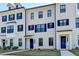 Elegant white brick townhome showcasing dark blue shutters, dark trim, and a stylish dark blue front door at 3677 Sorrel Ln, Duluth, GA 30096