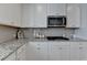 Bright kitchen featuring granite counters, white cabinets, and stainless microwave over the gas range at 3677 Sorrel Ln, Duluth, GA 30096