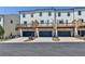Rear exterior of townhomes featuring private decks above garages with paved driveway at 3677 Sorrel Ln, Duluth, GA 30096