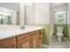 This bathroom features a wood vanity and a tub-shower with a window and white toilet at 8083 Cypress Ct, Villa Rica, GA 30180