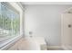 Bright bathroom with a large soaking tub and separate shower, illuminated by a window with wooded views at 8083 Cypress Ct, Villa Rica, GA 30180
