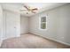 A simple bedroom features neutral walls, a ceiling fan, and a window providing natural light at 8083 Cypress Ct, Villa Rica, GA 30180