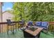 Cozy back deck featuring a fire pit, comfortable seating, and a view of the surrounding trees at 3215 Rose Petal Ln, Powder Springs, GA 30127