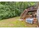 Spacious backyard with a wooden deck, lush trees, stairs and AC units for outdoor enjoyment at 3215 Rose Petal Ln, Powder Springs, GA 30127
