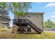 View of the home's back exterior, featuring a wooden deck and staircase leading down to the yard at 3215 Rose Petal Ln, Powder Springs, GA 30127