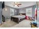 Cozy bedroom featuring a ceiling fan, a large window and a bed with a patterned comforter at 3215 Rose Petal Ln, Powder Springs, GA 30127