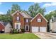 Elegant brick home with a two-car garage, beautiful landscaping, and classic architectural details at 3215 Rose Petal Ln, Powder Springs, GA 30127
