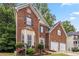 Beautiful brick home with a manicured lawn, two car garage, and mature trees at 3215 Rose Petal Ln, Powder Springs, GA 30127