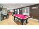 Basement game room featuring a pool table, wet bar, and entertainment area with a Miami Hurricanes theme at 3215 Rose Petal Ln, Powder Springs, GA 30127