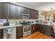 Modern kitchen featuring stainless steel appliances, dark cabinets and granite countertops at 3215 Rose Petal Ln, Powder Springs, GA 30127