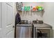 Functional laundry area with stainless steel Samsung washer and dryer, plus shelving for supplies at 3215 Rose Petal Ln, Powder Springs, GA 30127