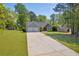 Charming home with a two-car garage, surrounded by a green lawn, mature trees, and a driveway in a suburban setting at 5630 Tallantworth Xing, Cumming, GA 30040