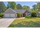 Charming single-story home with a two-car garage, well-manicured lawn, and mature trees in a serene suburban setting at 5630 Tallantworth Xing, Cumming, GA 30040