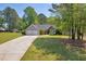 Suburban home with a two-car garage and a well-maintained lawn surrounded by lush green trees under a bright sky at 5630 Tallantworth Xing, Cumming, GA 30040