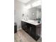 Bathroom with double sink vanity, large mirror, and wood-look floors at 1976 Boyd Trace Nw Ln, Atlanta, GA 30318