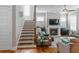 Inviting living room featuring a cozy fireplace, hardwood staircase, and ample natural light at 1976 Boyd Trace Nw Ln, Atlanta, GA 30318