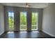 Bedroom with hardwood floors, light gray walls, and large windows with a treeline view at 1274 Longreen Terrace # 113, Atlanta, GA 30318