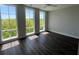 Bedroom with hardwood floors, light gray walls, and large windows with a treeline view at 1274 Longreen Terrace # 113, Atlanta, GA 30318