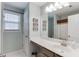 Bright bathroom with a large mirror, modern vanity, and shower with curtain, providing a functional space at 1641 Rocky Knoll Ln, Dacula, GA 30019