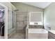 Luxury bathroom featuring tile shower, standalone tub, and quartz countertops at 1641 Rocky Knoll Ln, Dacula, GA 30019