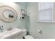 Cozy bathroom with mint green walls, decorative mirror and shelving, and a modern vanity at 1641 Rocky Knoll Ln, Dacula, GA 30019