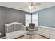 Tranquil Bedroom features soft blue walls, white furniture, and a comfortable rocking chair, creating a serene atmosphere at 1641 Rocky Knoll Ln, Dacula, GA 30019