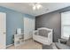 Cozy bedroom with neutral carpet, ceiling fan, and white baby crib at 1641 Rocky Knoll Ln, Dacula, GA 30019