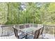 Spacious wooden deck with a dining table and lush green trees in the background at 1641 Rocky Knoll Ln, Dacula, GA 30019