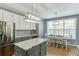 A modern kitchen features stainless appliances, white cabinetry, and an island with granite countertop at 1641 Rocky Knoll Ln, Dacula, GA 30019