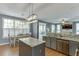 Open-concept kitchen featuring an island, granite countertops, dining area, and seamless flow into the living room at 1641 Rocky Knoll Ln, Dacula, GA 30019