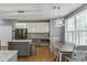 Well-lit kitchen featuring white cabinets, stainless appliances, an island, and a dining area with a large window at 1641 Rocky Knoll Ln, Dacula, GA 30019