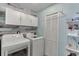 Well-lit laundry room with modern washer and dryer, plus overhead cabinets at 1641 Rocky Knoll Ln, Dacula, GA 30019