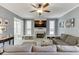 Bright living room featuring a ceiling fan, fireplace with mounted TV, and comfortable gray furniture at 1641 Rocky Knoll Ln, Dacula, GA 30019