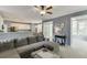 Open concept living room featuring gray walls, large sectional sofa, and view into the kitchen at 1641 Rocky Knoll Ln, Dacula, GA 30019