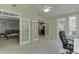 Bright sunroom with vaulted ceiling and multiple windows, and view into living room at 1641 Rocky Knoll Ln, Dacula, GA 30019